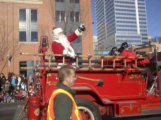 Santa waving from an antique fire truck at a Christmas parade. Click to see more parade photos! Santa Claus waving at a Christmas Parade
